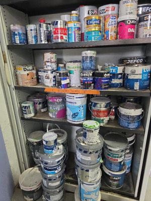 many cans of paint on the shelves in the room