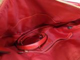 a red purse with a cell phone inside of it