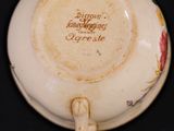 a small cup with a saucer on it on a black surface