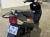 un scooter garé dans un garage, avec une plaque d'immatriculation à l'arrière