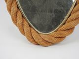 a mirror with a rope around it on a table