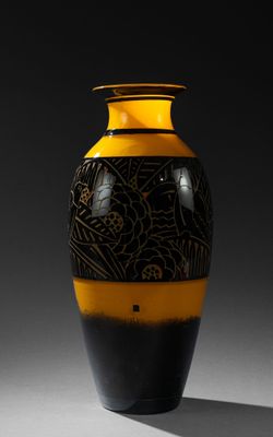 un vase noir et jaune posé sur une table