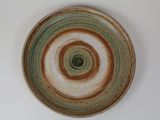 une assiette marron et verte posée sur une table blanche