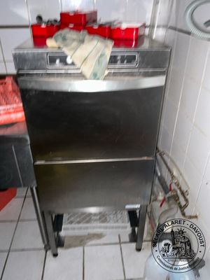a silver stove in a kitchen with a can of soda on the floor