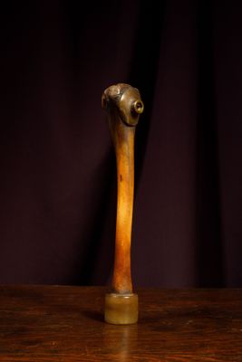 a wooden stick on a table with a purple curtain in the background