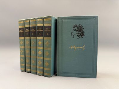 quatre livres sont alignés sur une surface blanche