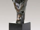 bronze sculpture of a hand holding a ball on a black base