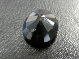 the faceted black diamond is on the surface of the table