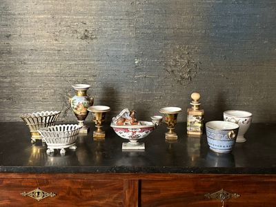 de nombreux vases et coupes de toutes sortes posés sur une commode