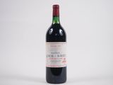 une bouteille de vin rouge posée sur une table blanche