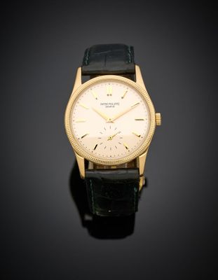 une montre-bracelet plaquée or, avec un cadran blanc et un bracelet en cuir noir