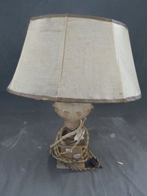 une image représentant une lampe entourée d'une corde, posée sur une table