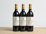 three bottles of wine sitting on top of a wooden table