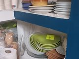 many plates and bowls on the shelves in the kitchen