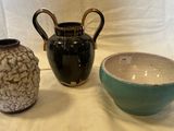 trois vases posés l'un à côté de l'autre sur une table