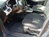 the interior of a car with the door open and a suitcase in the passenger seat