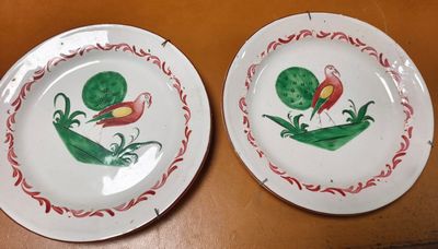 two plates that have been painted with flowers on them