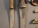many different types of knives on display on the wall