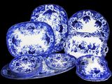 des assiettes, tasses et soucoupes bleues et blanches sur la table