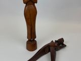 figurine en bois représentant une femme et un lézard sur fond blanc