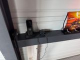 une photo montrant un téléphone portable et un DVD posés sur une étagère