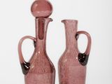 pair of pink glass vases on a white surface with a white background