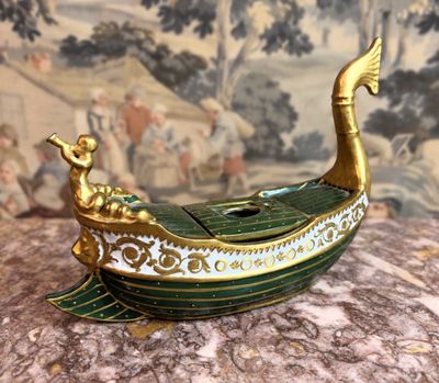 un bateau doré et vert posé sur une surface de marbre