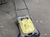 yellow and black push mower laying on the ground in a garage