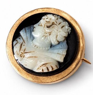 gold - plated brooch depicting a bust of a man in a black and white cameo