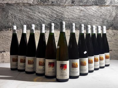bottles of wine are lined up on a table in front of a stone wall