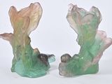 two figurines that are sitting on a white surface