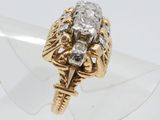 a close up of a gold and diamond ring on a clear surface