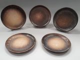 quatre assiettes marron empilées les unes sur les autres sur une table