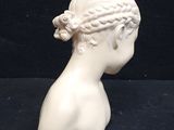 a white statue of a woman with braids on her head