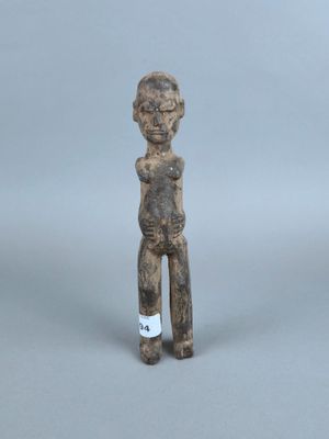 une vieille figurine représentant un homme debout, les mains sur les hanches