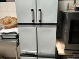 a refrigerator in the middle of a kitchen with a lot of food on top of it