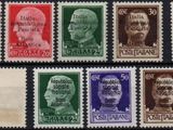 a group of stamps with different faces on them on a black surface