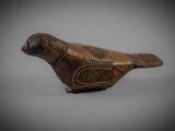 an old wooden bird with a decorative pattern on it ' s body