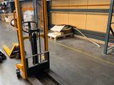 a forklift in a warehouse with pallets on the floor