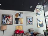 un canapé dans une pièce où il y a beaucoup de tableaux accrochés au mur