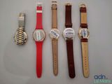 four watches are lined up in a row on a table