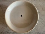 a white bowl with a hole in it on a marble table