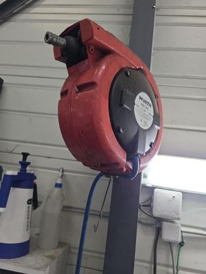 une borne d'incendie rouge fixée à un poteau dans un garage