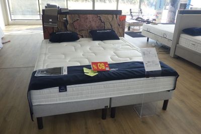 un lit qui se trouve au milieu d'une pièce remplie de meubles