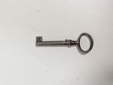 an old key hanging on a wall in a room
