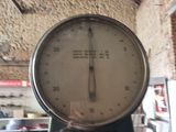 a large scale with a clock on it in a room