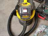 a yellow and black vacuum sitting on the floor next to a tool box