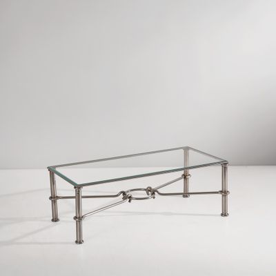 une table basse en verre avec des pieds en métal et un plateau en verre