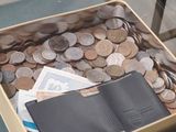une valise remplie de pièces de monnaie et un passeport posés sur une table