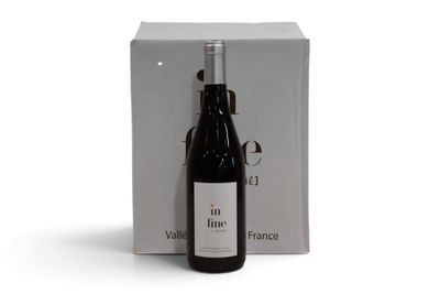 la bouteille de vin est à côté de la boîte sur la table
